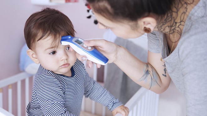 mother using forehead thermometer